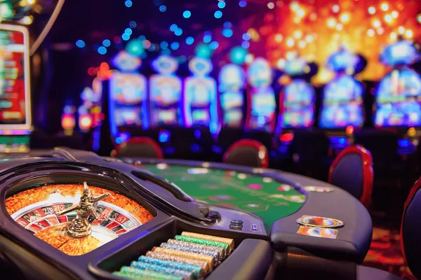 A man celebrating a winning moment on his laptop while gaming symbols float around him, capturing the excitement of ZS999 games.